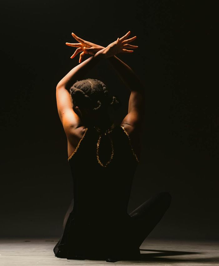 Woman performing a stable yoga pose in a dark pearl studio atmosphere